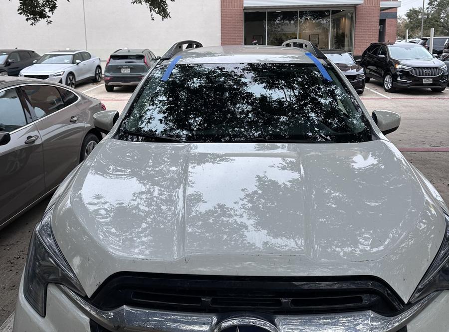 White Subaru Ascent with a new windshield in an office parking lot
